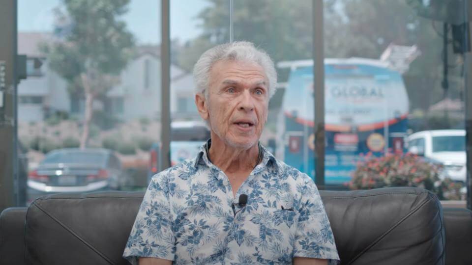 Elderly man wearing Hawaiian button-up shirt giving his video testimonial